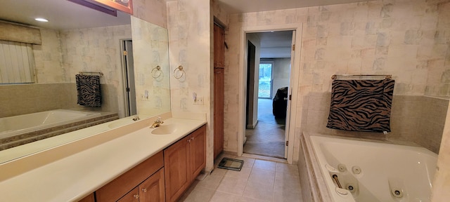 full bath with vanity, tile patterned floors, a tub with jets, and tile walls