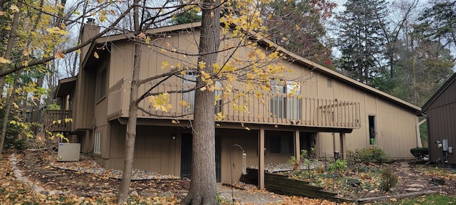 rear view of property with a deck and a chimney