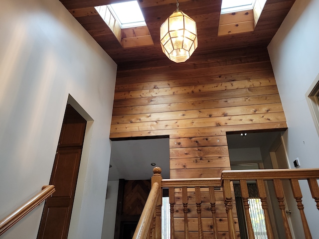 interior space with wood ceiling, a skylight, and a high ceiling