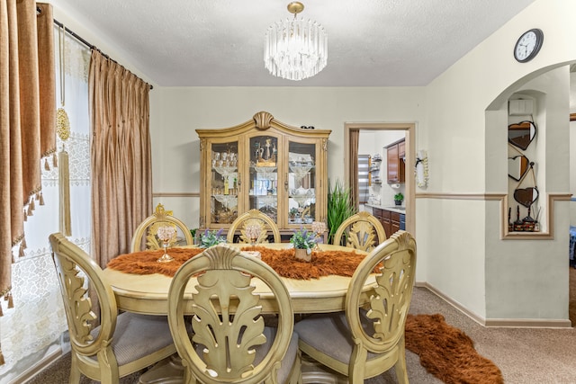 carpeted dining room with a textured ceiling and a chandelier