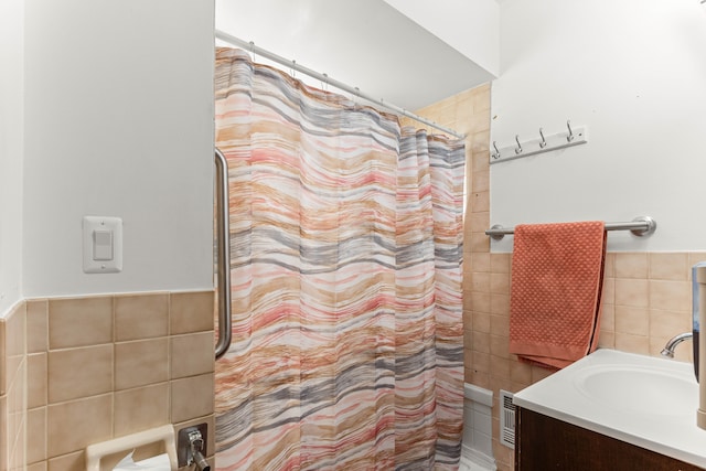 bathroom featuring vanity, tile walls, and walk in shower