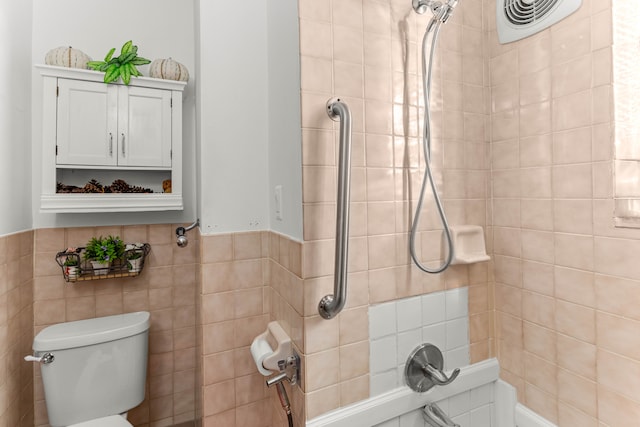 bathroom featuring toilet and tile walls