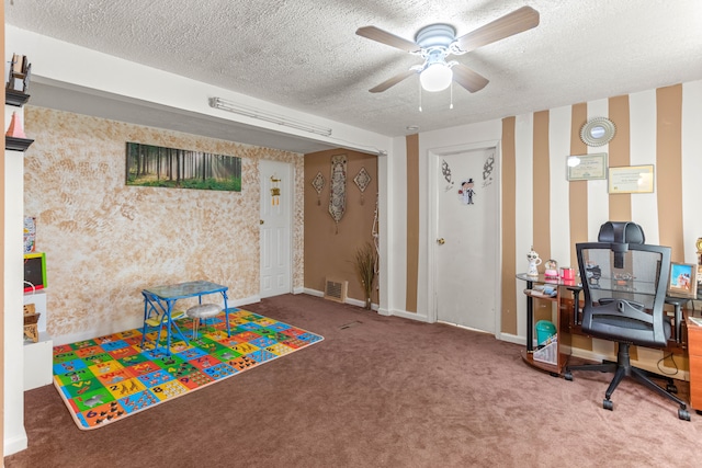 recreation room with ceiling fan, carpet floors, and a textured ceiling