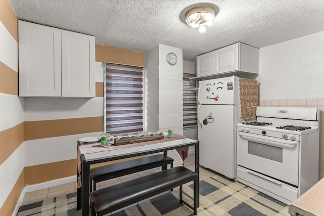 kitchen featuring white cabinetry, white appliances, and a textured ceiling