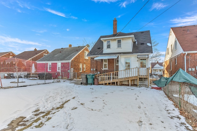 view of snow covered rear of property