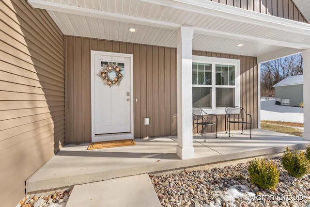 doorway to property featuring board and batten siding and a porch