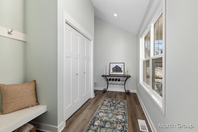 interior space with visible vents, lofted ceiling, baseboards, and wood finished floors