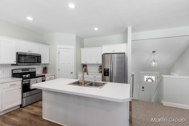 kitchen with appliances with stainless steel finishes, white cabinetry, an island with sink, and a sink