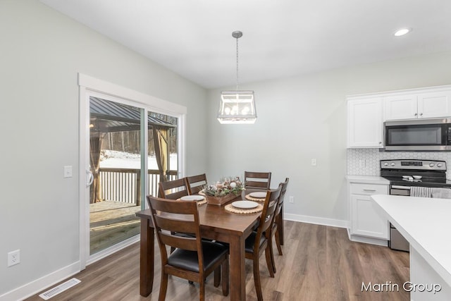 dining space featuring visible vents, dark wood-type flooring, recessed lighting, baseboards, and a chandelier