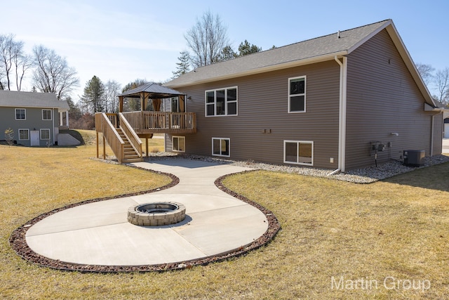 back of property with a patio, an outdoor fire pit, a gazebo, stairway, and a yard