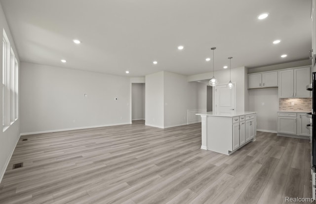 50050 Bluebell St, Canton, MI 48188 - kitchen featuring recessed lighting, light wood-type flooring, decorative backsplash, light countertops, and open floor plan