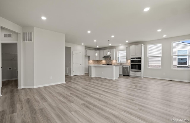 50050 Bluebell St, Canton, MI 48188 - unfurnished living room featuring healthy amount of natural light, light wood-style flooring, and recessed lighting
