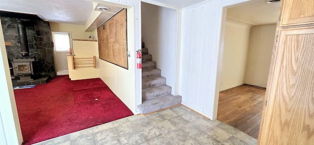 below grade area featuring a wood stove and stairway