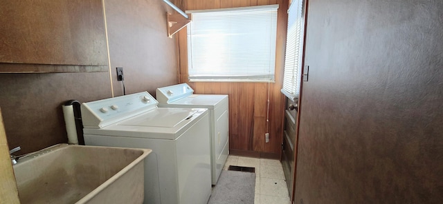 laundry area featuring independent washer and dryer and wood walls