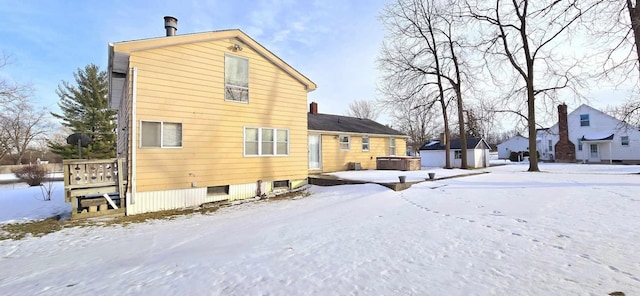 snow covered property featuring a hot tub