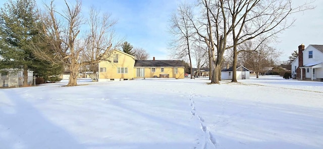 yard layered in snow featuring a storage shed