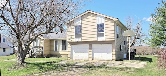 tri-level home with a garage, a front lawn, and driveway