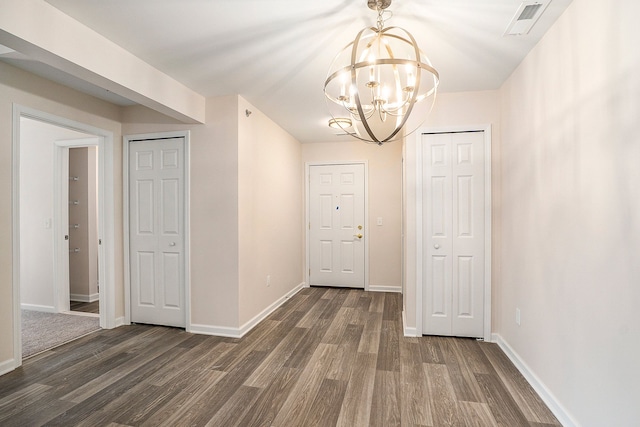 hallway featuring dark hardwood / wood-style floors and a chandelier