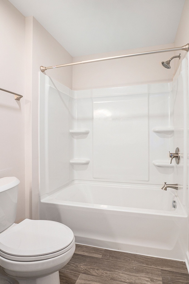 bathroom with toilet, tub / shower combination, and hardwood / wood-style floors