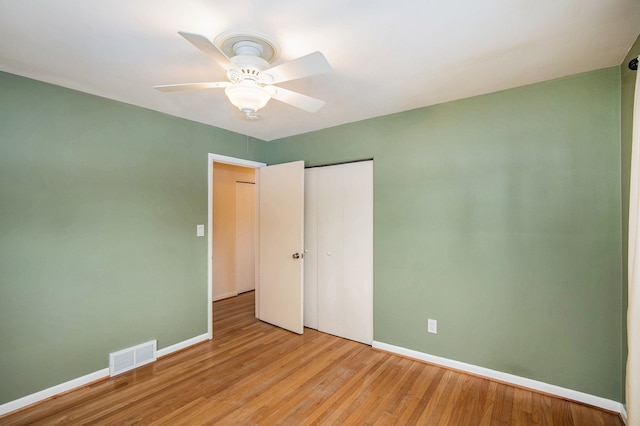 unfurnished bedroom featuring ceiling fan, a closet, and light hardwood / wood-style flooring