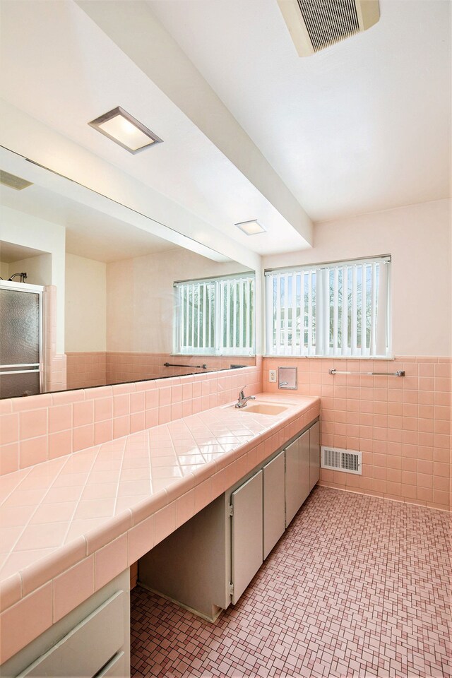 bathroom with sink and tile walls