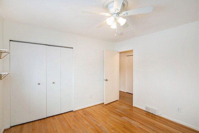 unfurnished bedroom with ceiling fan, light hardwood / wood-style floors, and a closet