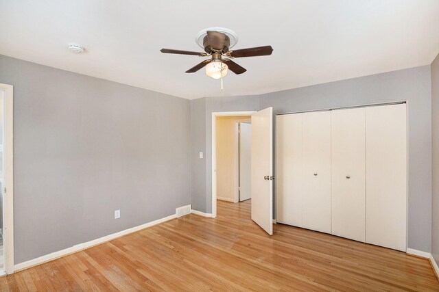 unfurnished bedroom with ceiling fan, a closet, and light wood-type flooring