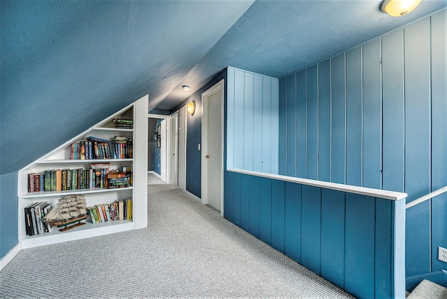 bonus room featuring vaulted ceiling, light carpet, and built in features