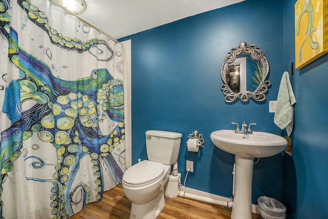 bathroom with hardwood / wood-style floors, a shower with shower curtain, and toilet