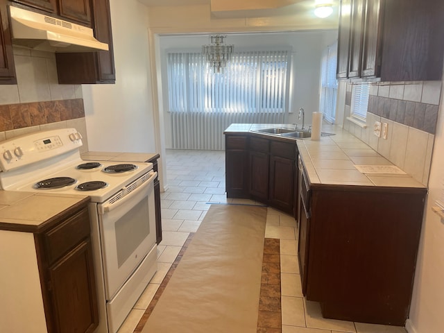 kitchen with dark brown cabinetry, sink, electric range, and decorative backsplash