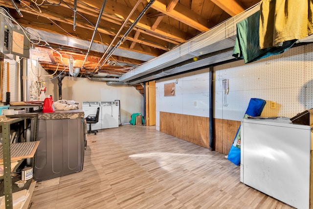 basement featuring light hardwood / wood-style flooring, washer and clothes dryer, and refrigerator