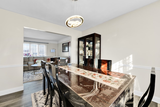 dining room featuring an inviting chandelier, hardwood / wood-style floors, and bar