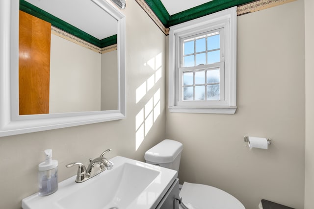 bathroom featuring vanity, a wealth of natural light, and toilet