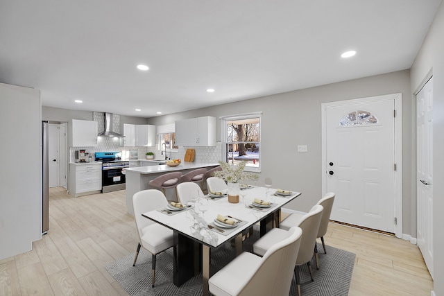 dining room featuring sink and light hardwood / wood-style flooring