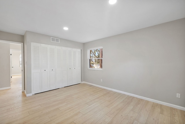 unfurnished bedroom with light hardwood / wood-style flooring and a closet