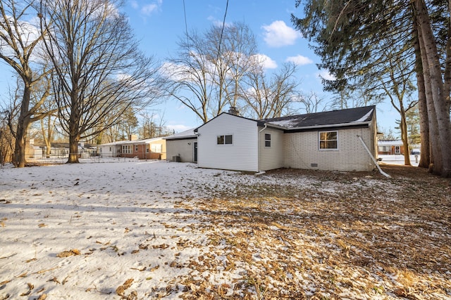 view of snow covered back of property