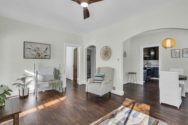 living room with dark wood-type flooring and ceiling fan