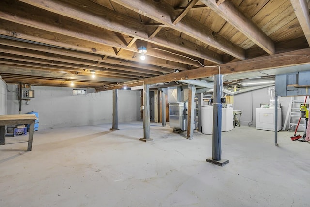 basement featuring electric panel, washer and clothes dryer, and heating unit