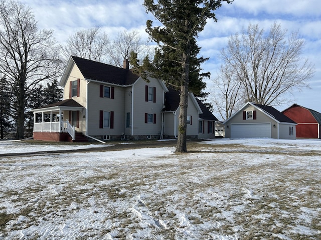 view of front facade featuring a garage, an outdoor structure, and covered porch