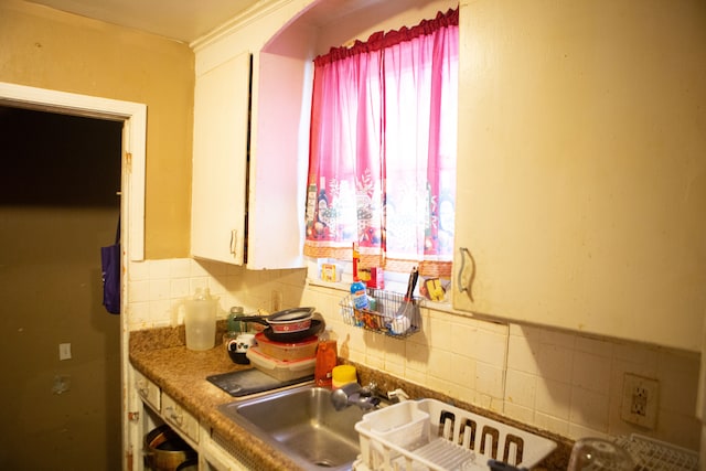 kitchen featuring white cabinetry and backsplash