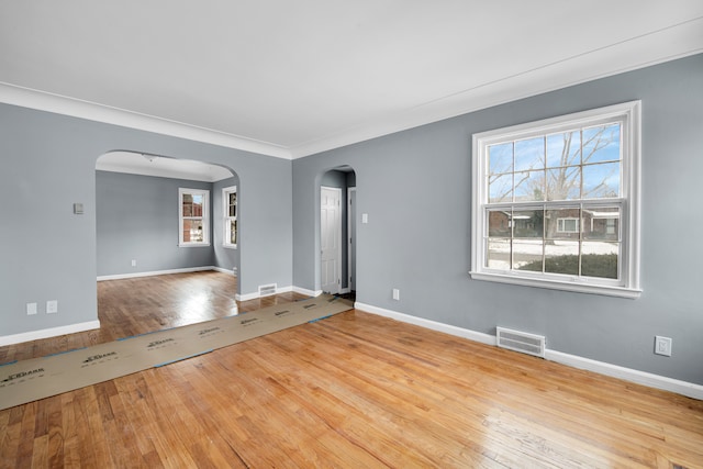 empty room featuring ornamental molding and light wood-type flooring