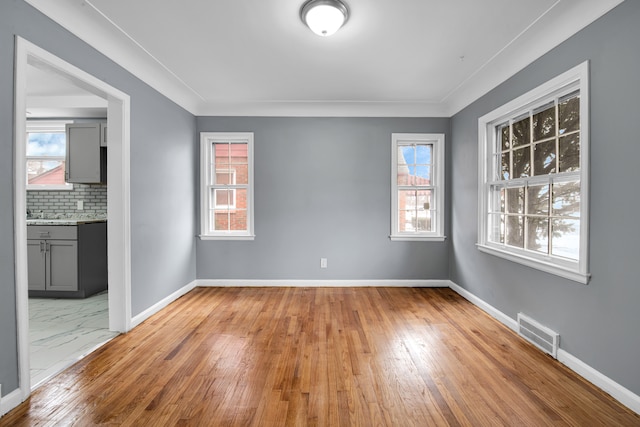 unfurnished room with hardwood / wood-style flooring and crown molding