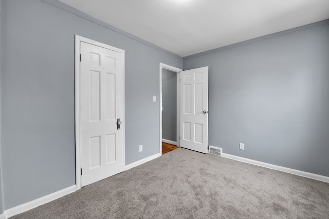 unfurnished bedroom featuring crown molding and carpet floors