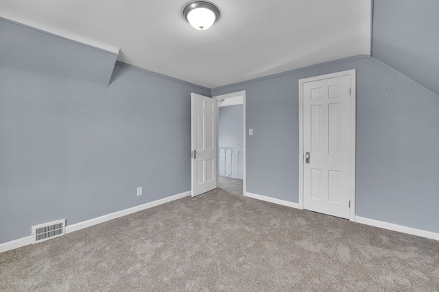 additional living space featuring vaulted ceiling and light carpet