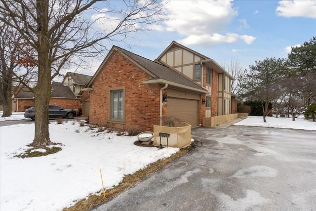 view of snowy exterior featuring a garage