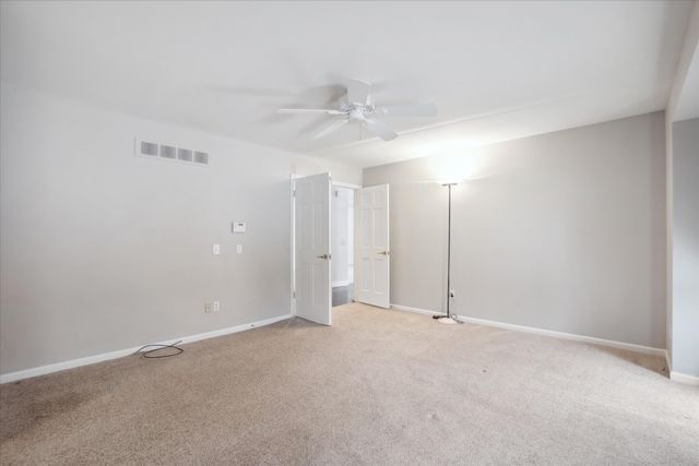 empty room featuring light carpet and ceiling fan