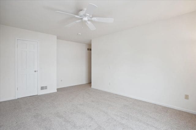 carpeted spare room with ceiling fan