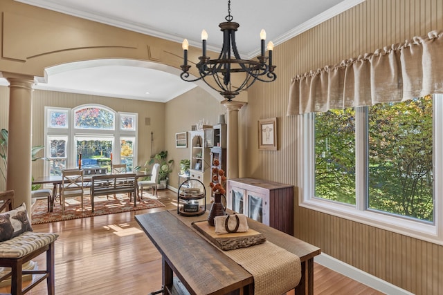 dining area featuring decorative columns, crown molding, plenty of natural light, and light wood-type flooring