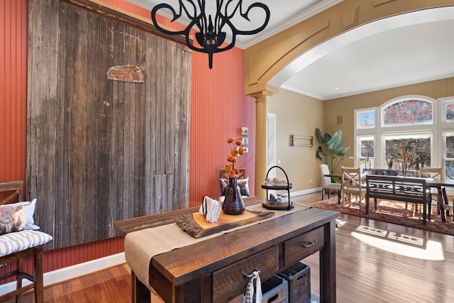 dining room featuring hardwood / wood-style floors, ornamental molding, and decorative columns