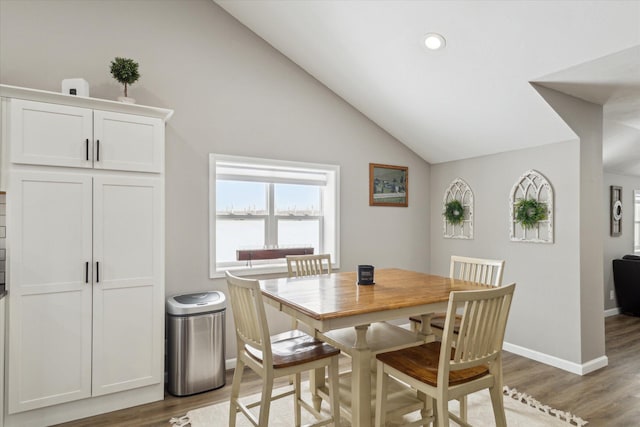 dining space with dark hardwood / wood-style flooring and vaulted ceiling